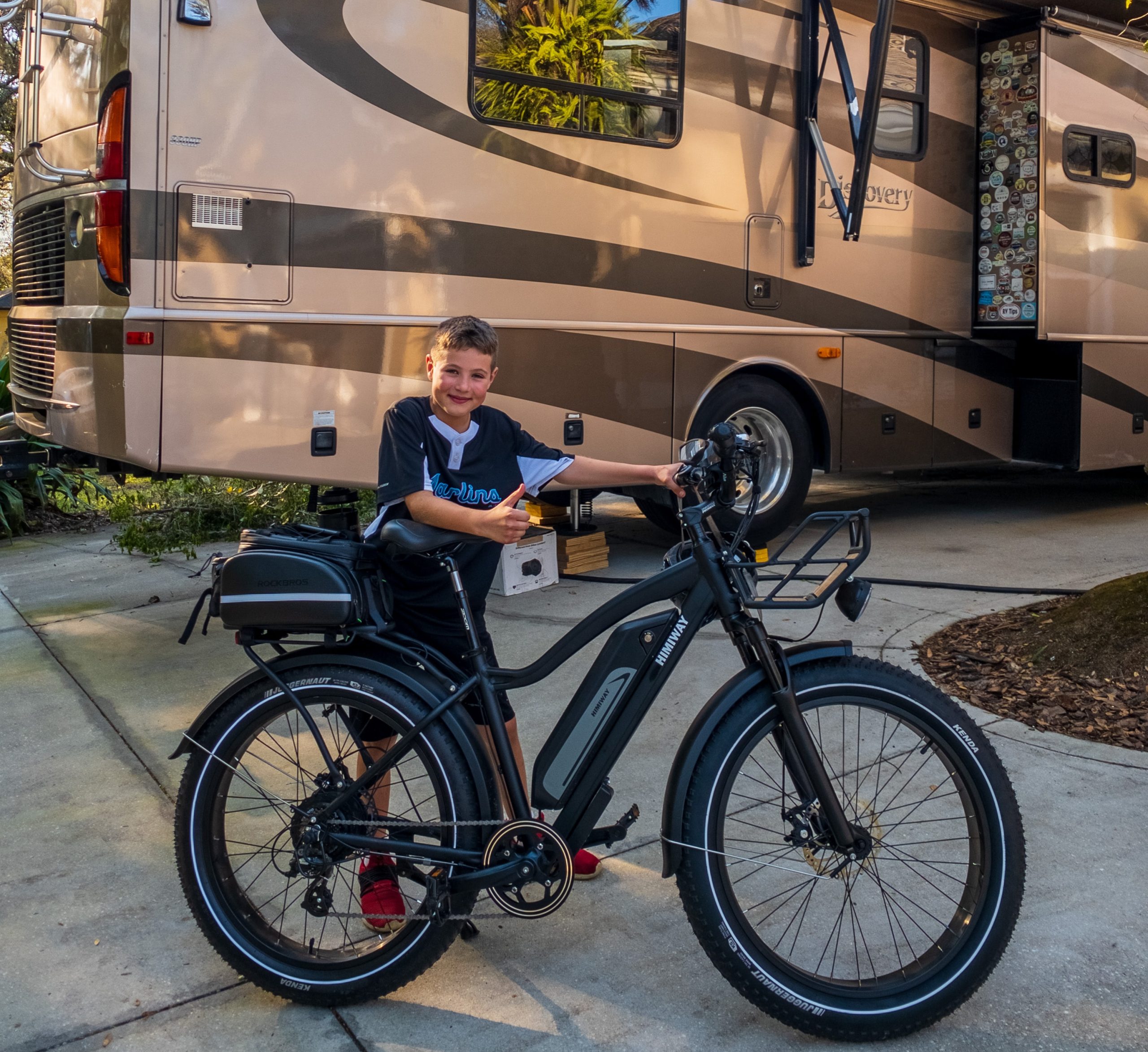 boy and an electric bike next to a class C motorhome