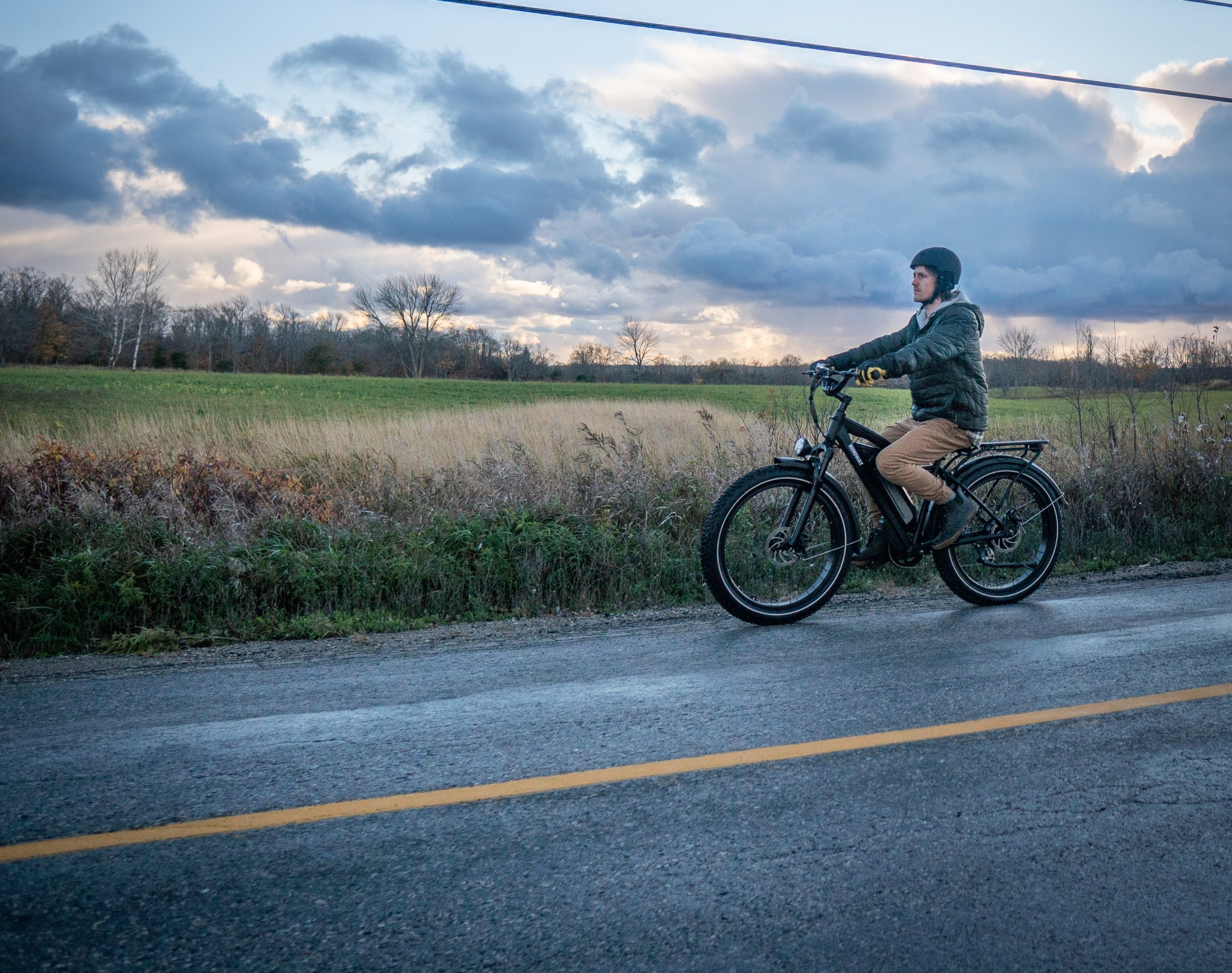woman riding her electric bike down a country road in the rain
